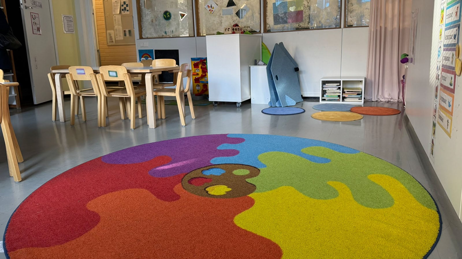 Päiväkoti Sunshine Sorsapuiston lasten leikkitila ja värikäs matto