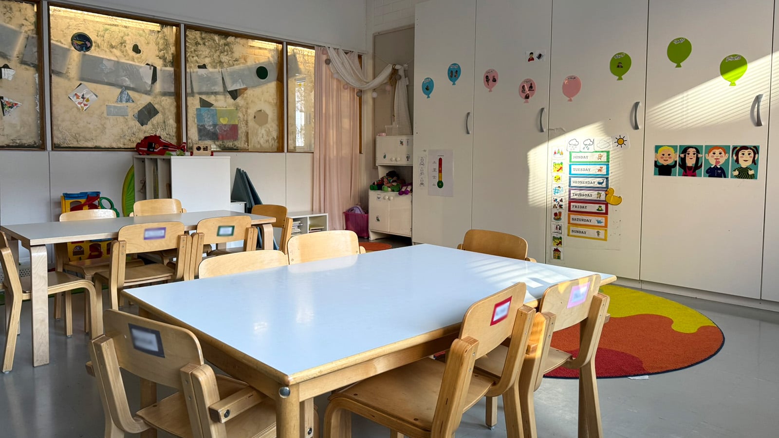 Päiväkoti Sunshine Sorsapuiston ryhmätila ja lasten pöydät sekä tuolit