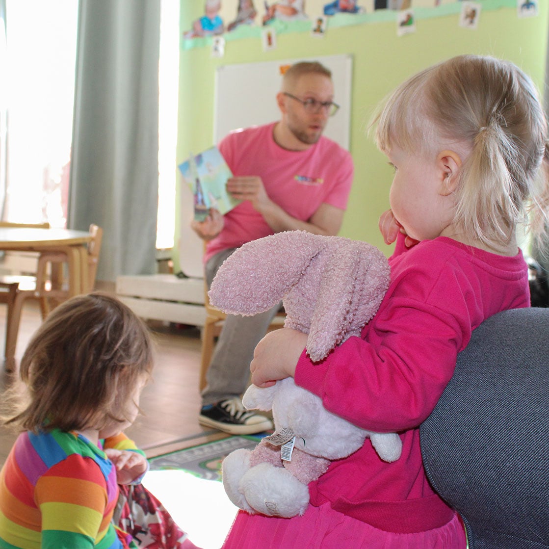 Varhaiskasvatuksen opettaja lukee kirjaa päiväkodin lapsille
